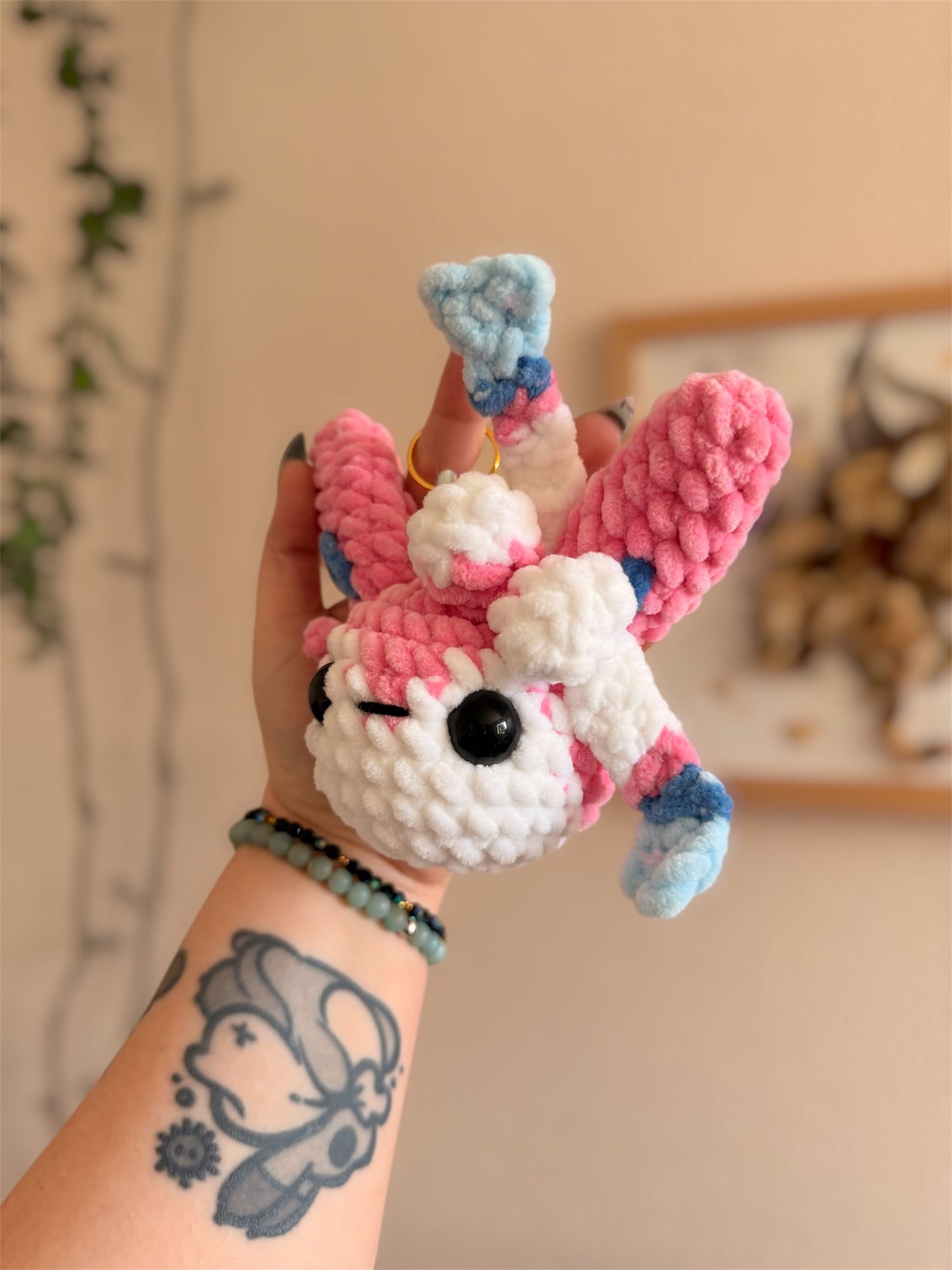 Porte-Clés/Bijou de sac Nymphali au Crochet – Amigurumi Pokémon fait main
Craquez pour ce beau porte-clés/bijou de sac Nymphali (Sylveon) au crochet, une création artisanale unique inspirée de l’univers Pokémon et crochetée à la main par mes soins.
Un Pokémon de collection en version crochet
Crochetée avec de laine chenille et de rembourrage ouate certifiés Oeko-Tex, notre porte-clés Nymphali en crochet combine douceur inégalable et originalité.