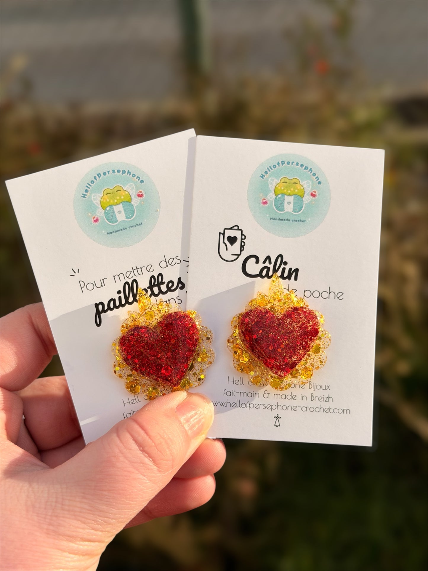 Ajoute une note de poésie et d’amour à ton look avec ce joli pin’s cœur Ex Voto en résine et paillettes, entièrement réalisée à la main dans mon petit atelier. Chaque pièce est unique : coulée en résine UV transparente et agrémentée de paillettes scintillantes, elle capte la lumière et attire les regards.