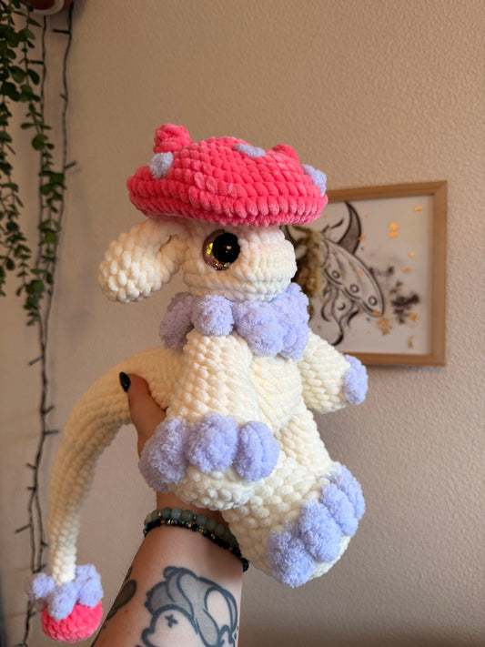 Ajoutez une touche de magie à votre quotidien avec cette peluche dragon au crochet, réalisée entièrement à la main dans des tons inspirés de l’automne et de la chasse aux champignons. 🍄

Crochetée avec un fil chenille certifié Oeko-Tex et rembourrée de ouate hypoallergénique, cet amigurumi dragon&nbsp;convient aux collectionneurs comme aux amateurs de dragons et de cottagecore.